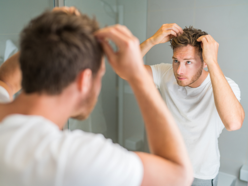 Uomo che verifica la situazione dei capelli