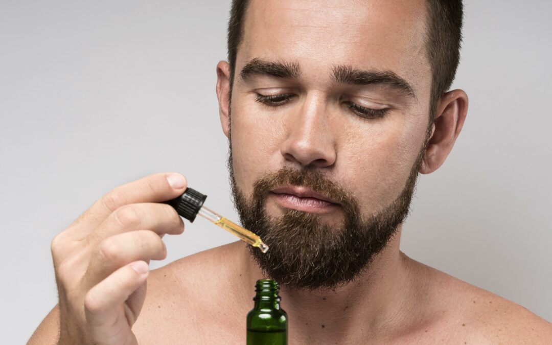 Uomo che tiene in mano una bottiglia di olio per il viso in primo piano.